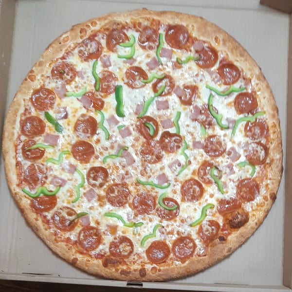 A Brooklyn Pizza pepperoni, ham, and green pepper pizza in a cardboard box.